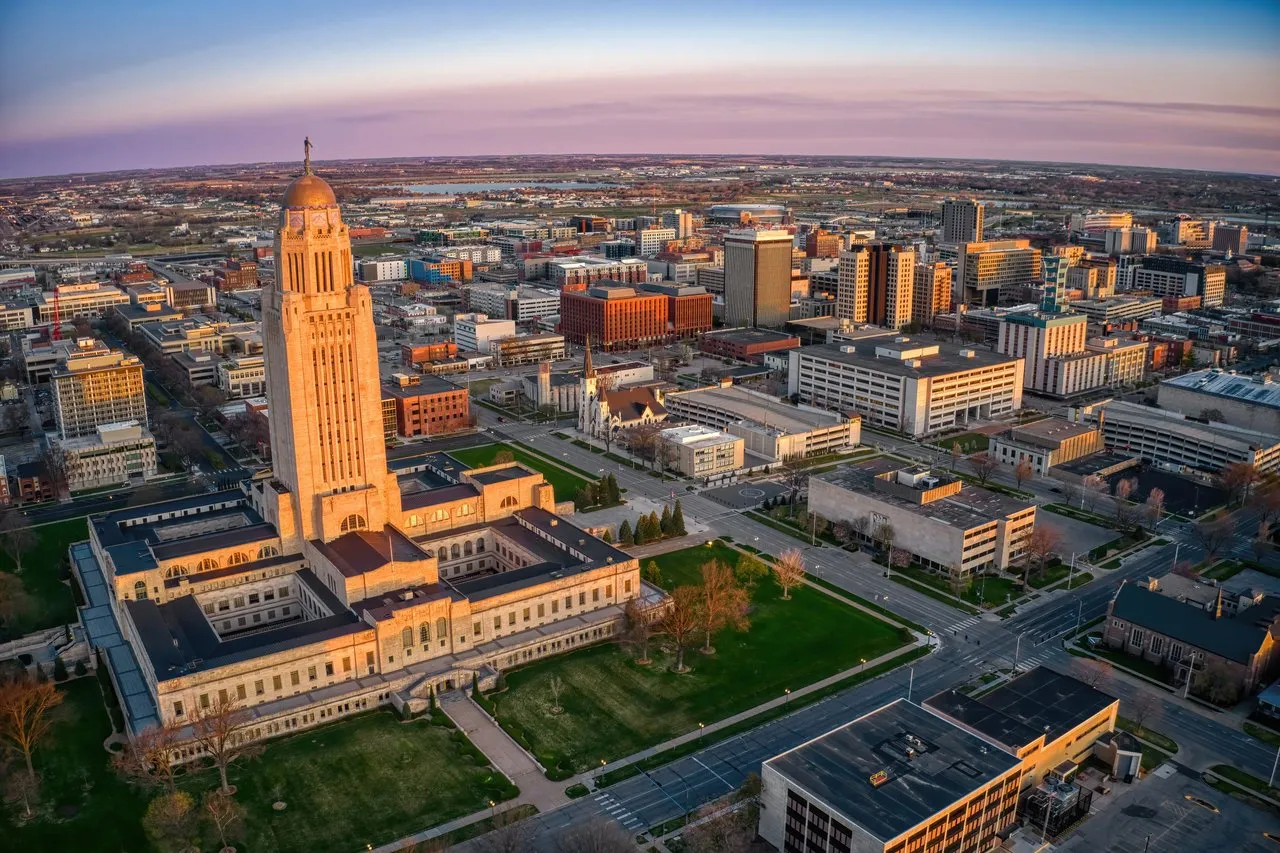 Downtown Lincoln skyline at golden hour, with the Nebraska State Capitol prominent in the foreground.