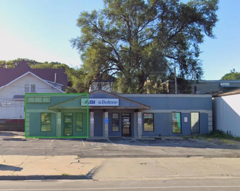 Commercial storefront with a green outline highlighting the left-side entrance and windows.