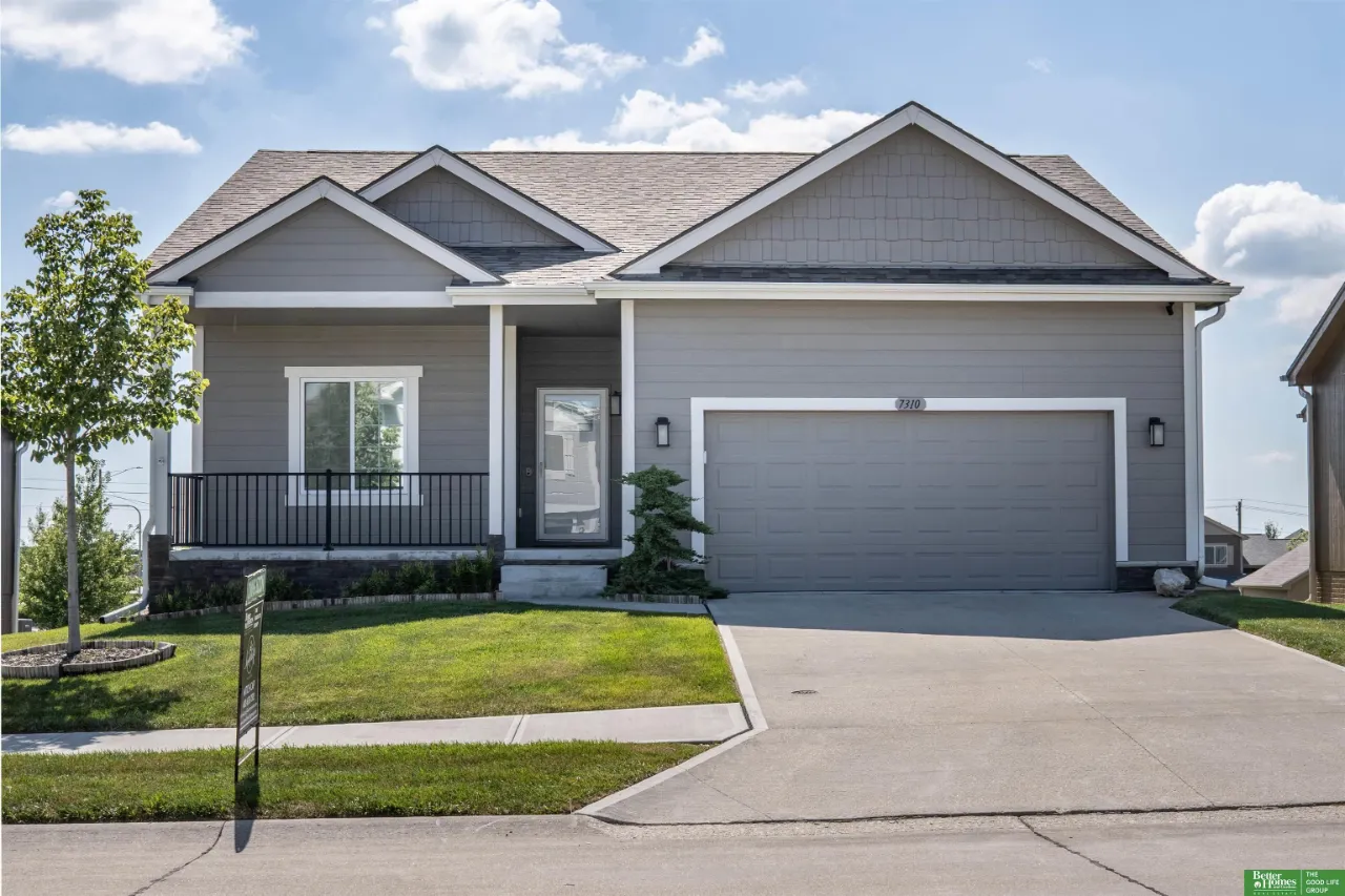 Gray single-story home with multiple gables, a covered porch, and a two-car garage.